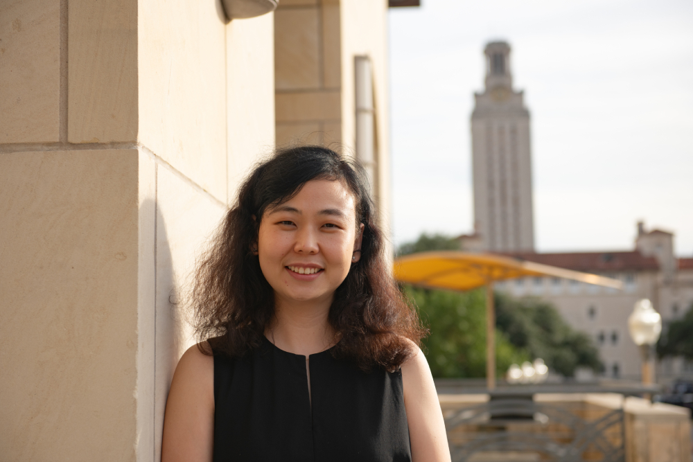 Qian Yin stands in front of the UT Austin Tower outside of the Department of Biomedical Engineering.