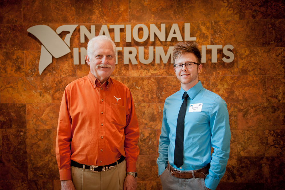 Two people standing in front of a National Instruments sign