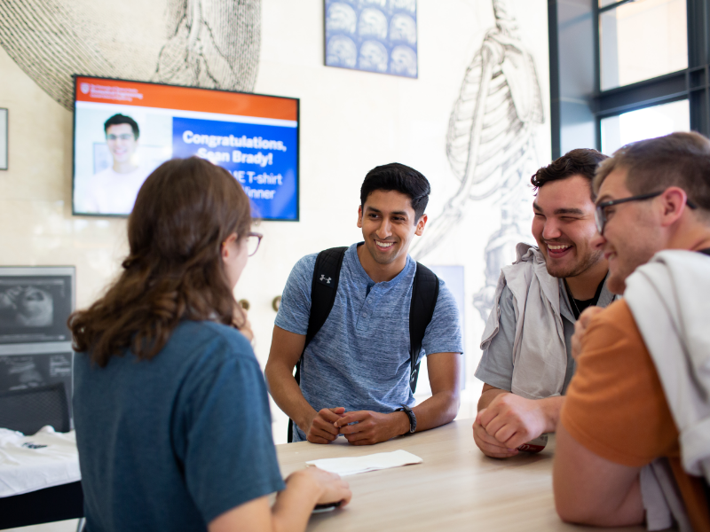 Texas BME students laughing around a table