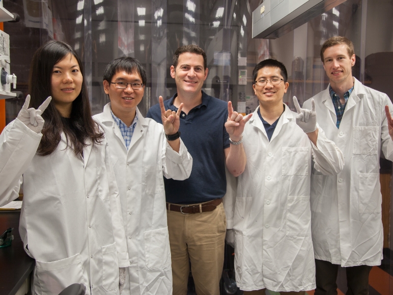 Texas biomedical engineering students doing hook 'em horns with professor