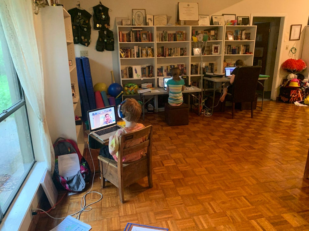 overhead view of living room with books and child sitting at desk