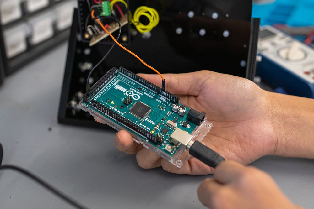 close up of hands holding computer chip plugged in