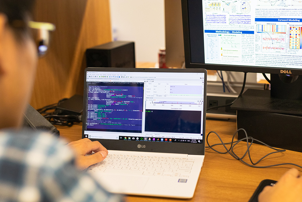 Person sits at laptop computer looking at screen