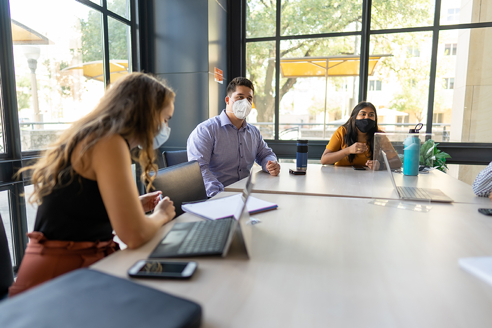 CID fellows sitting around a conference table wearing masks