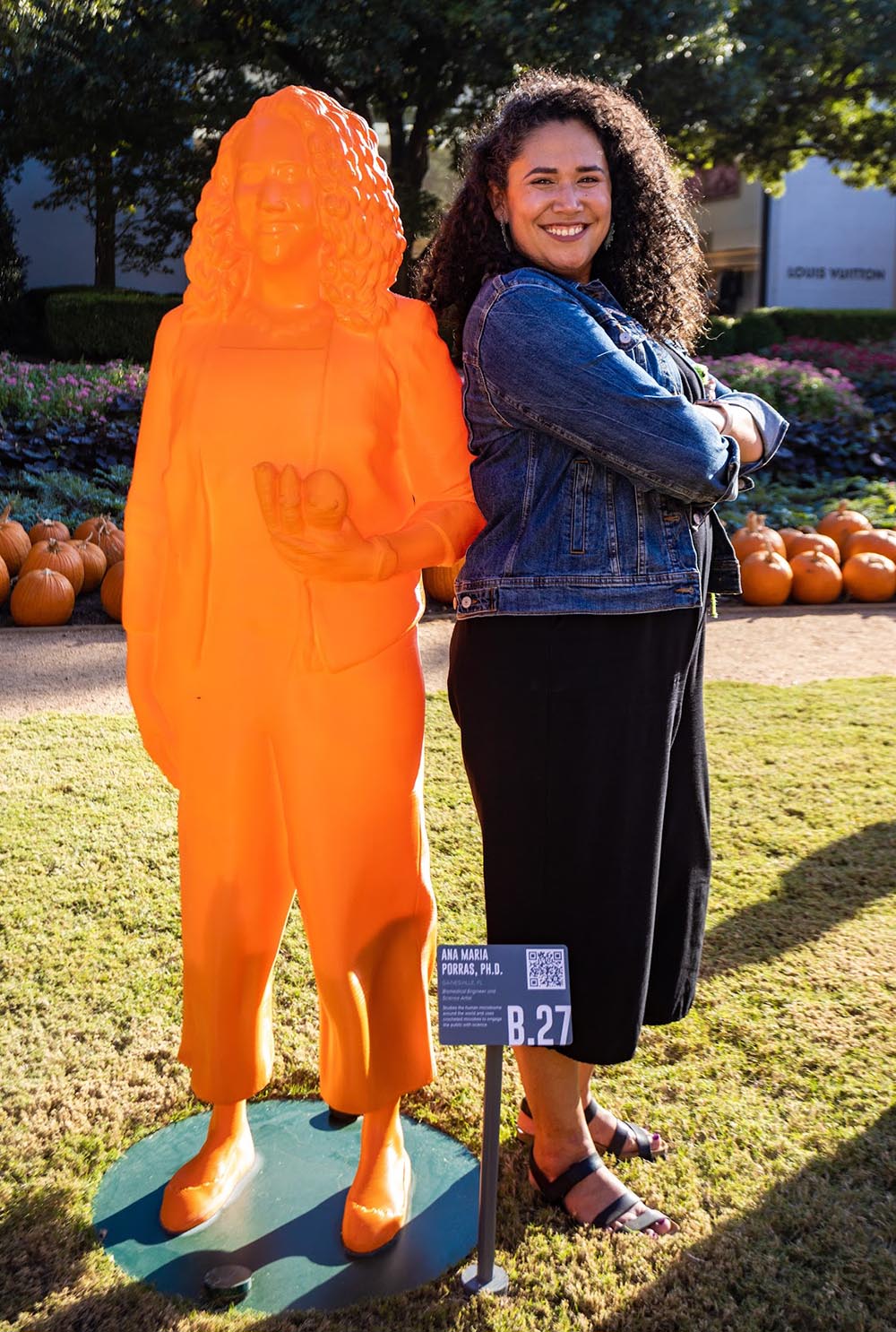 BME alumna Ana Maria Porras standing next to a statue of her likeness