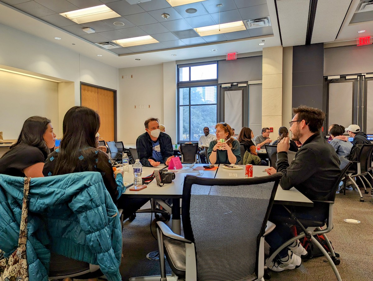 People sitting around a large table in office chairs