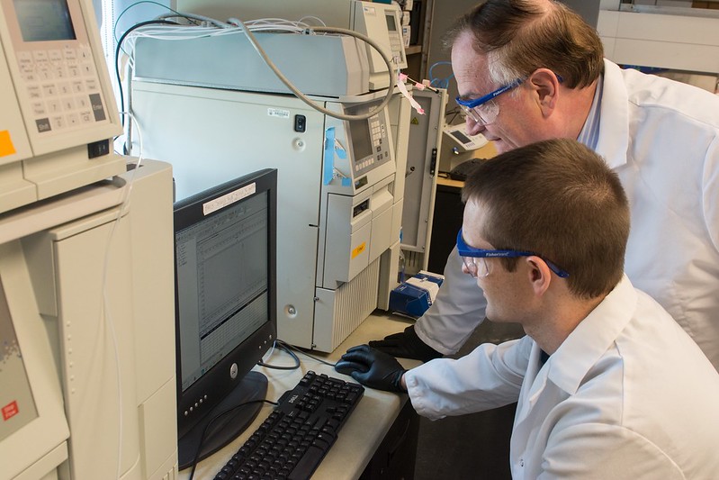 Peppas standing at computer with student in lab
