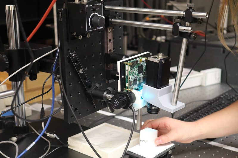 Hands working with microscope on lab table