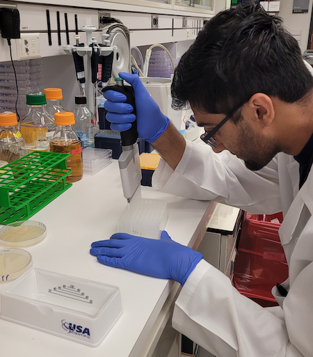 Maanas Gupta fills test tubes in lab