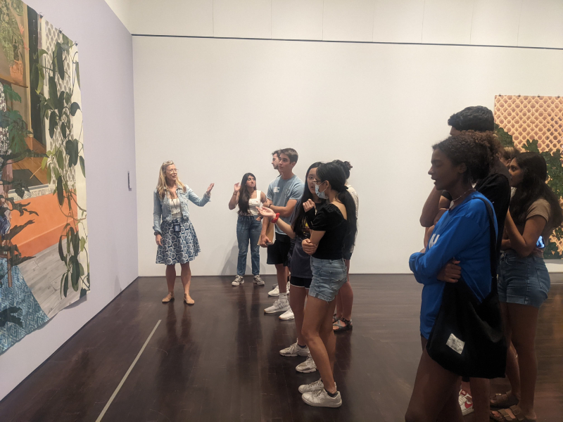 Woman talking to crowd about a piece of art in a museum