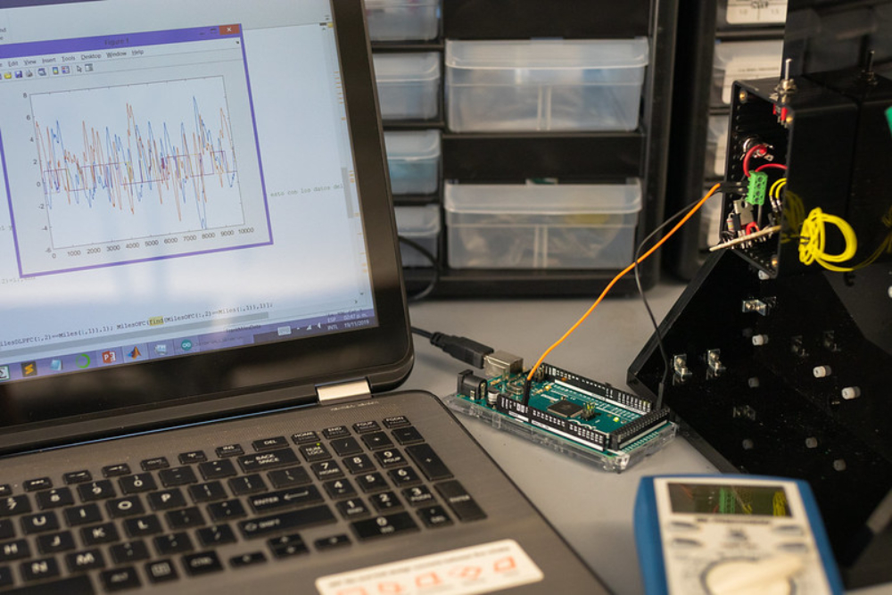 A computer connected by wires shows brainwave activity.
