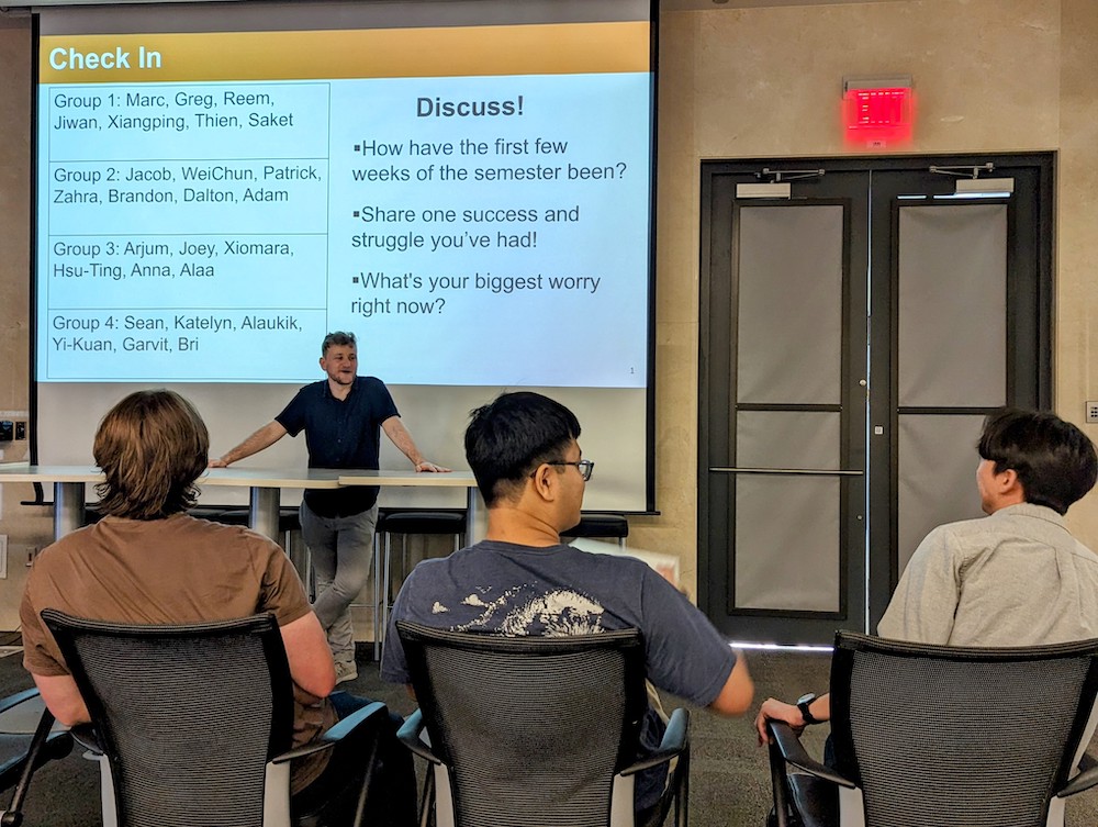 A crowd of students look at Biomedical Engineering student Noah Stern in front of a PowerPoint presentation.