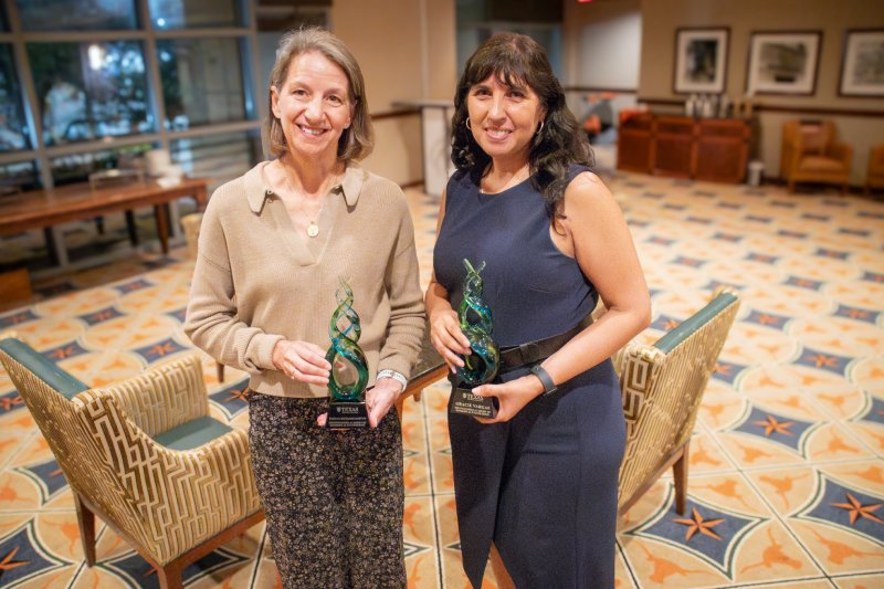 Gracie Vargas and Rebecca Richards-Kortum hold their awards while standing in the UT Club at DKR Stadium.