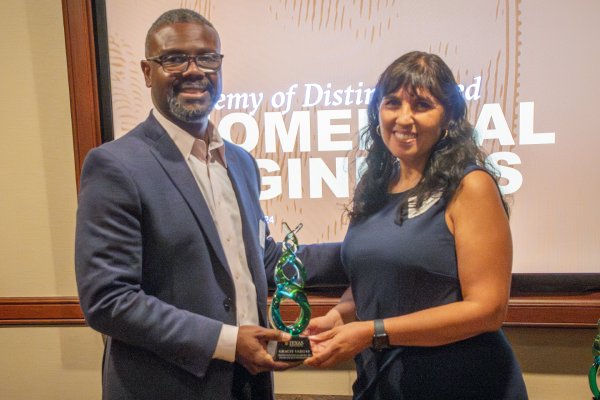 Gracie Vargas holding award and smiling with BME Department Chair Tyrone Porter