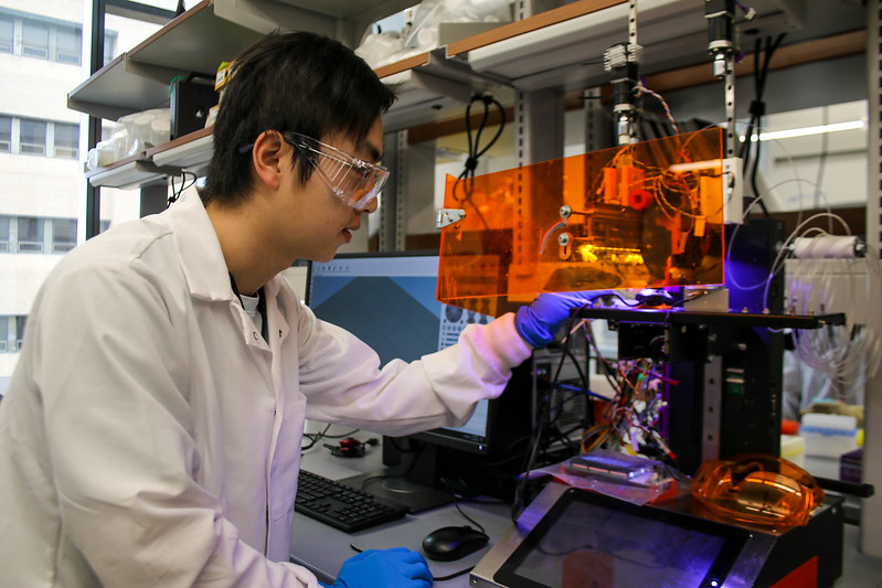 UT Austin Department of Biomedical Engineering graduate student works in a lab.