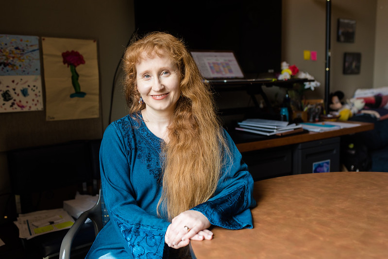UT Austin Biomedical Engineering Professor Mia Markey sits at a table.