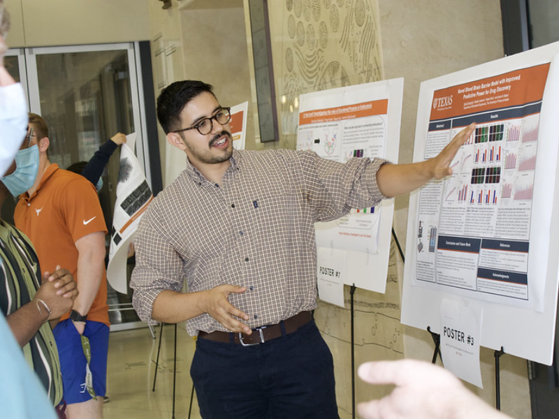 Texas BME student talking to faculty in front of research poster