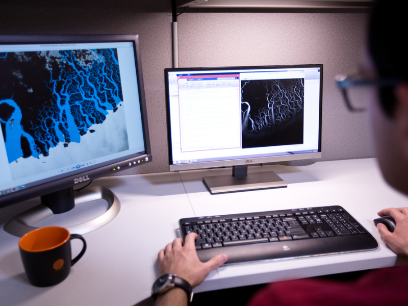 Man working at desk with multiple computer monitors
