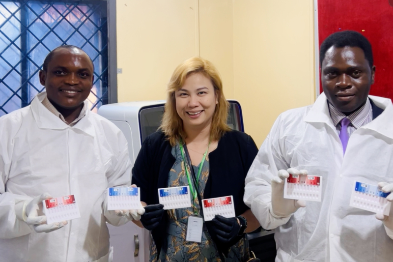 UT Austin Biomedical Engineering Professor Nuttada Panpradist stands with Nigerian researchers holding HIVDR tests.