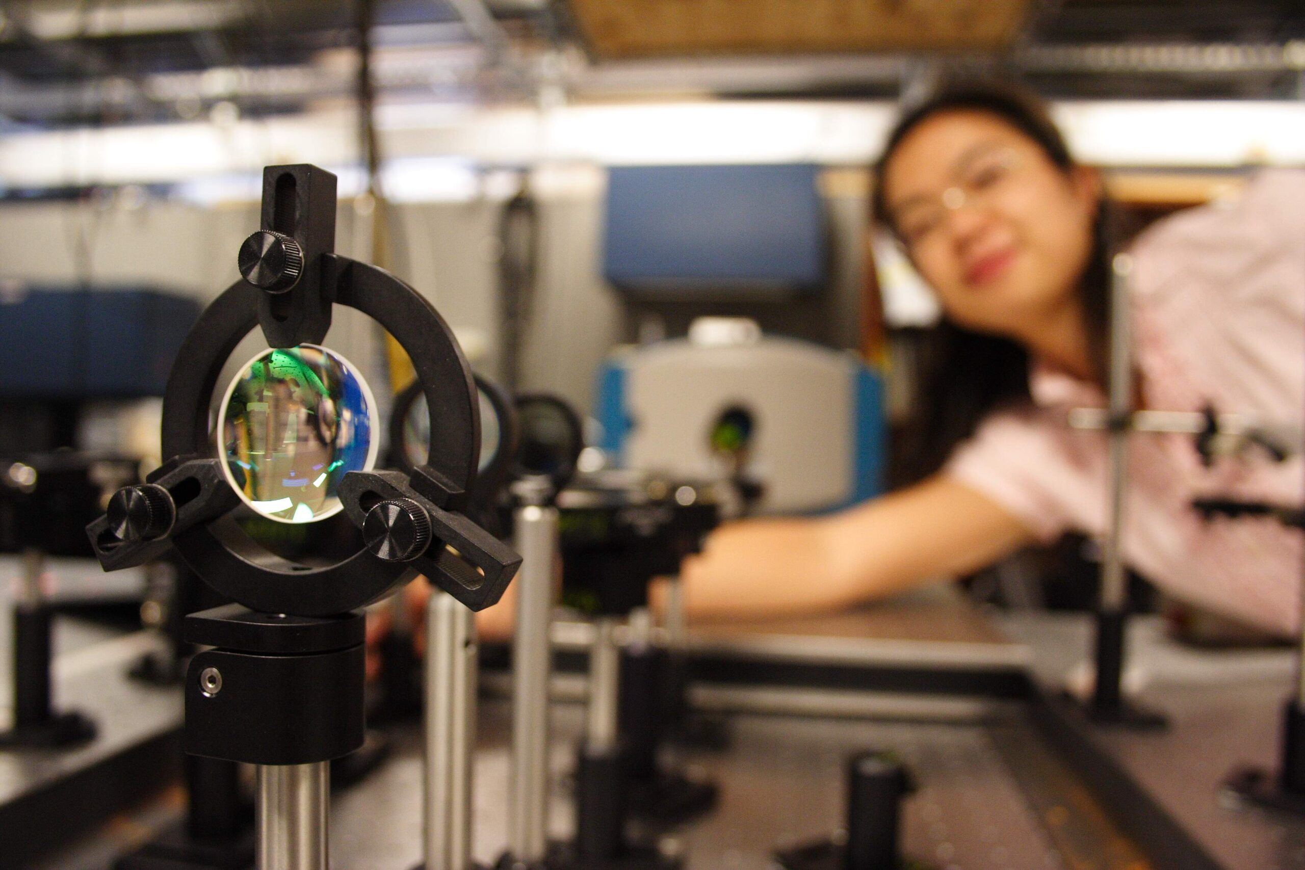 optical lens in the foreground being tested by a texas BME student