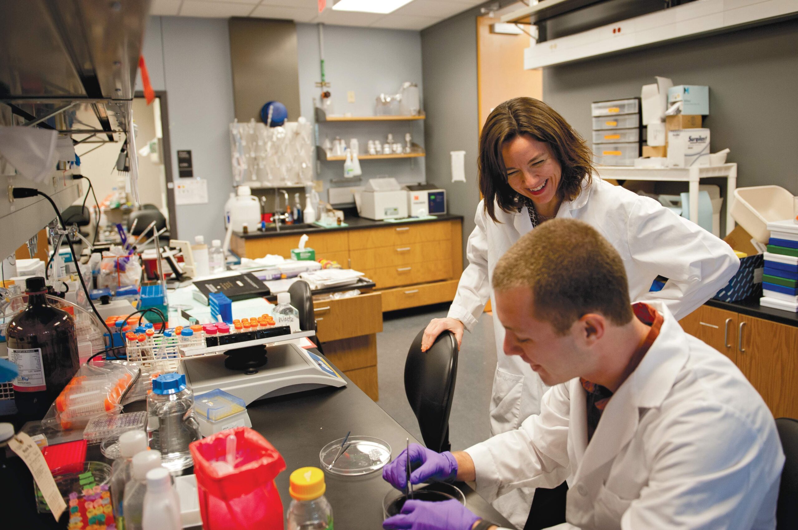 Professor Laura Suggs laughing in lab with graduate student