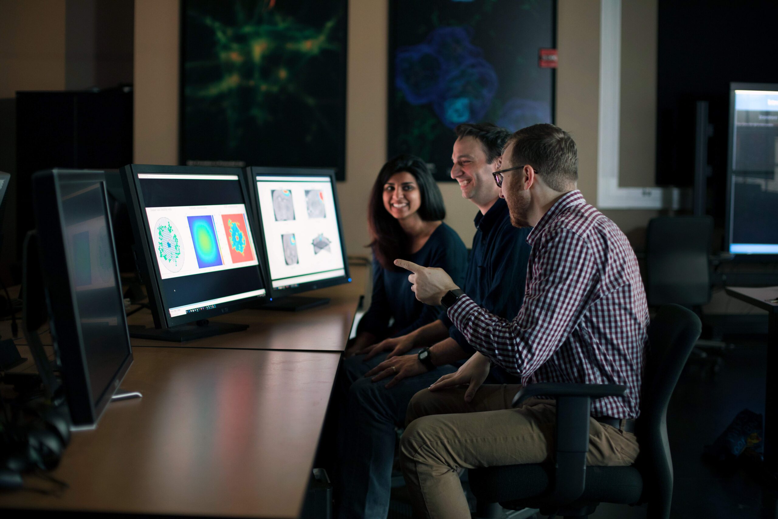 Texas BME faculty at a lab table looking at medial imaging scans