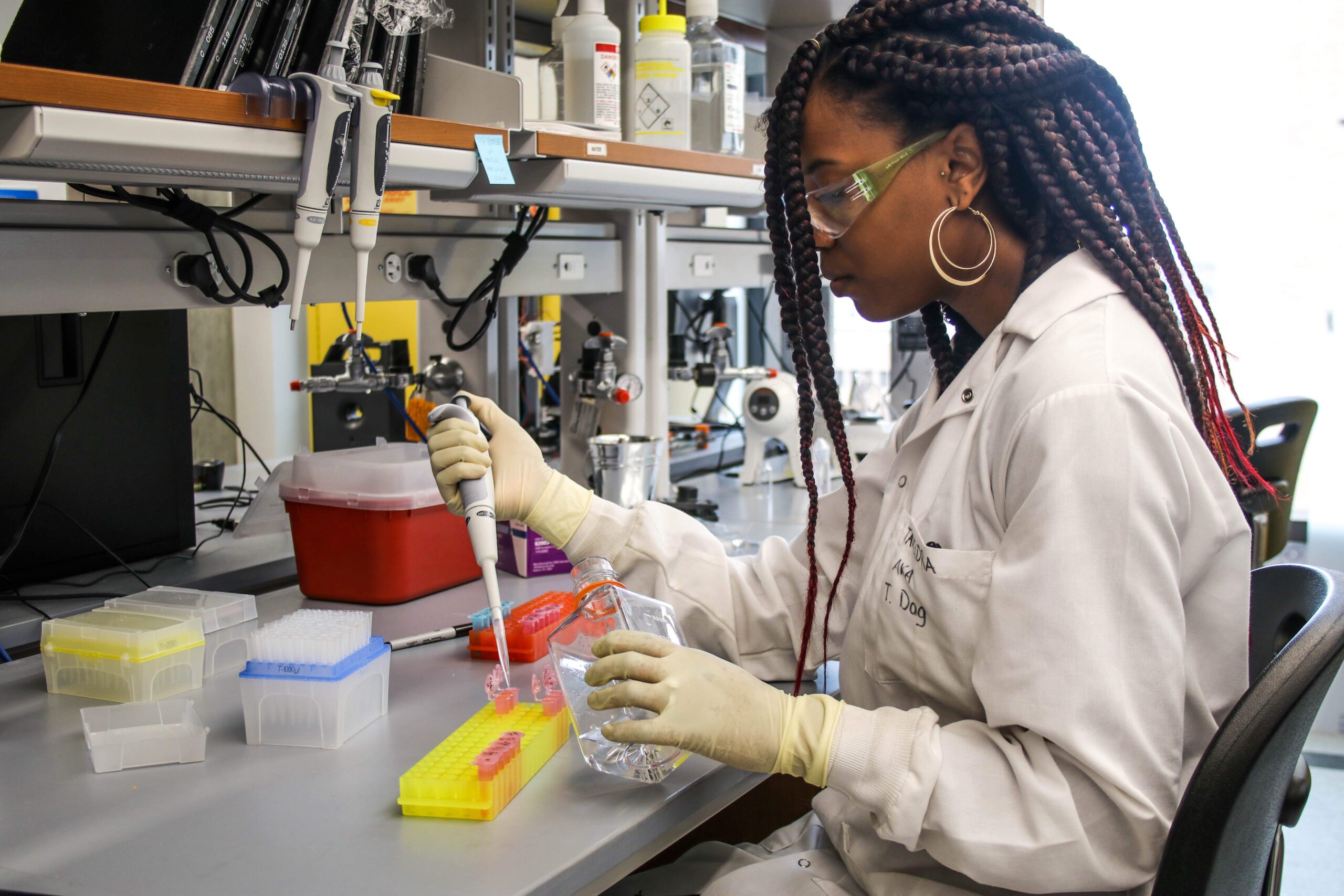 student holding a pipet filling vials at Texas BME