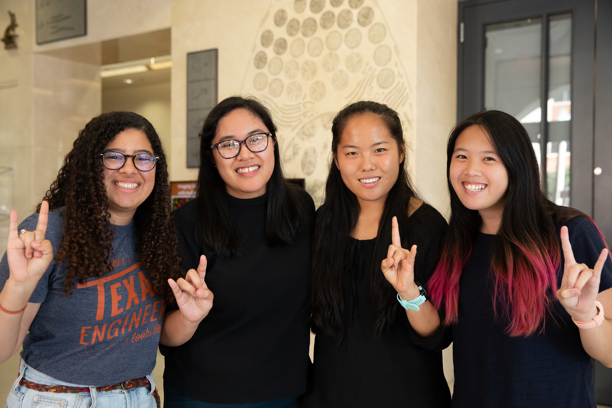 Texas BME students smiling and doing hook 'em horns hand sign
