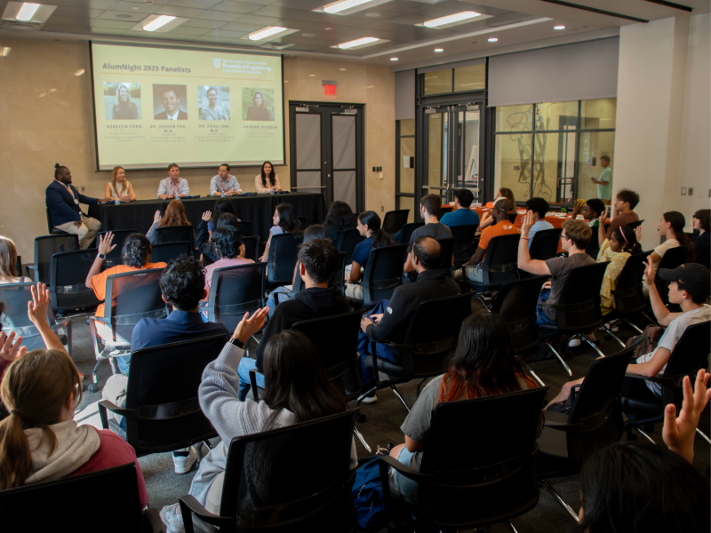 Texas Engineering students sitting in conference room in front of panel table of guest alumni speakers