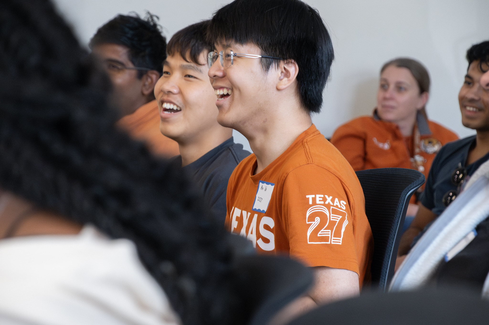 Texas BME students laughing in audience at AlumNight event