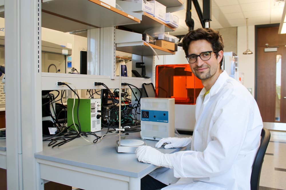 Manual Rausch in lab coat smiling sitting in a lab